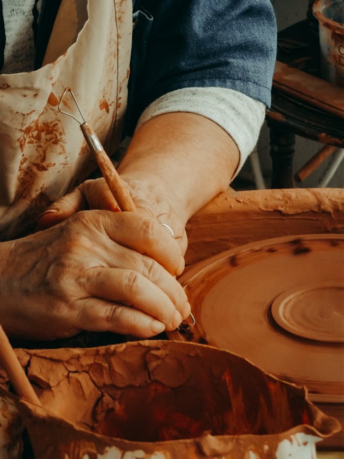 Close-up of hands crafting pottery on a spinning wheel, showcasing the art of ceramics.