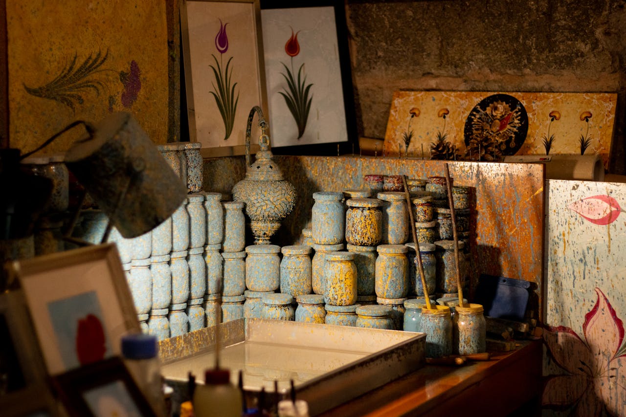 services-01 A cozy artisan workshop in Kayseri showcasing vibrant painted jars and artistic prints.