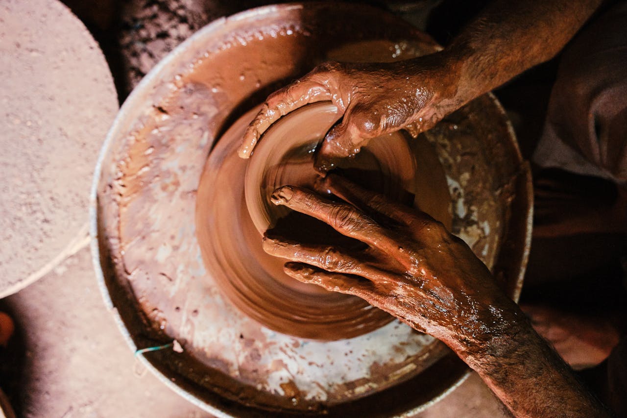 why-choose-us Artisan shaping clay on a pottery wheel, illustrating craftsmanship and creativity.