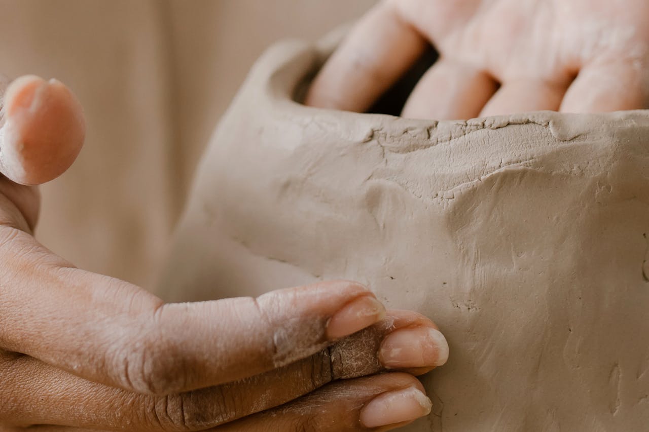 journey Close-up of hands shaping clay in pottery workshop, showcasing artisanal craft details.